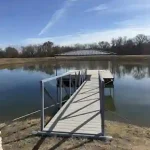Custom lake dock walkway with metal railings and a platform extending into calm water at Grand Lake Oklahoma