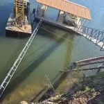 Covered boat dock and lift installation on Grand Lake Oklahoma with metal walkway and floating dock platform