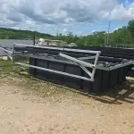 Partially assembled dock frame with metal railings and black float structure at a lakeside construction site in Grand Lake Oklahoma